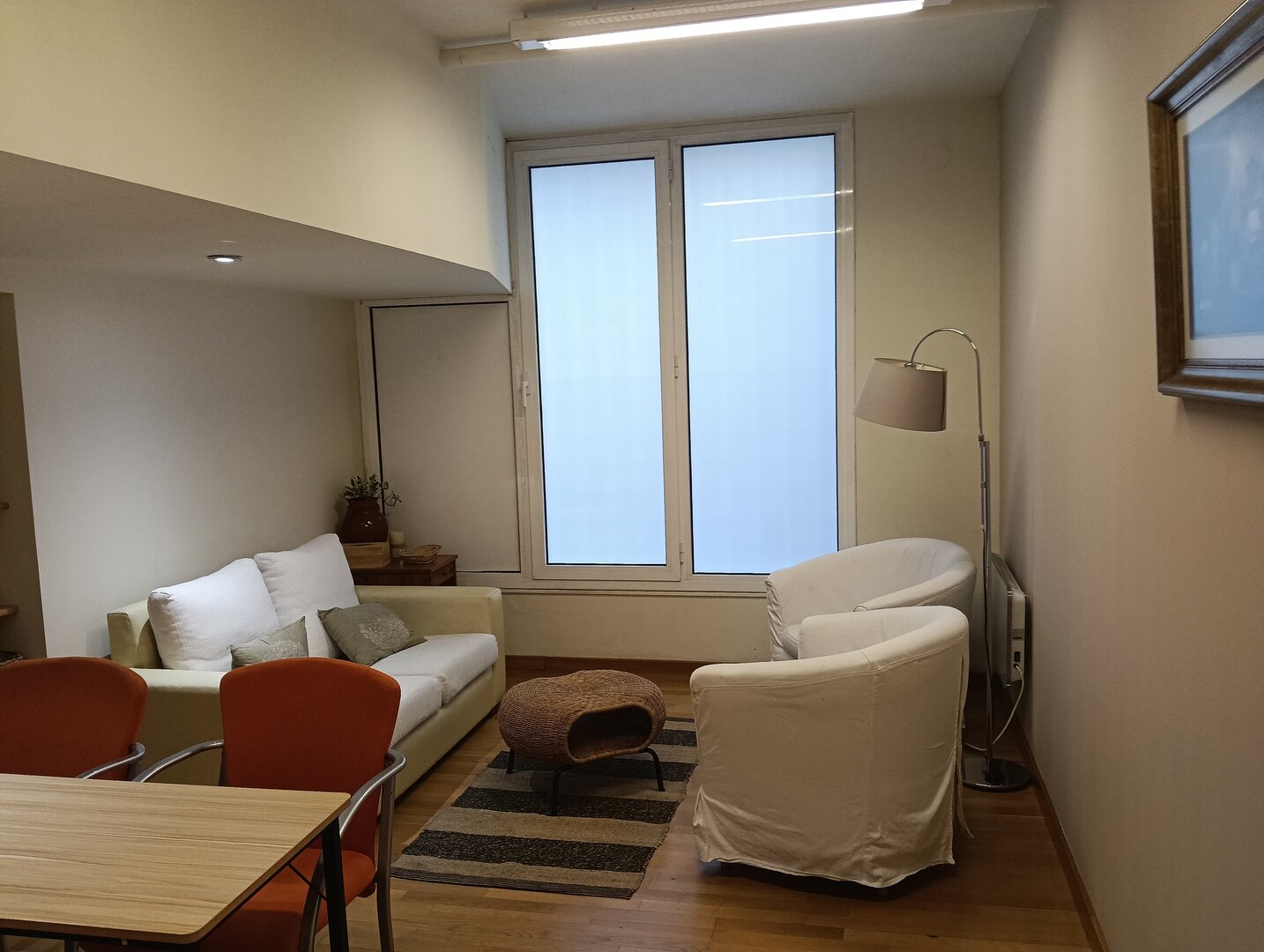 Sala de terapia con sillones y luz cálida preparada para sesiones de acompañamiento