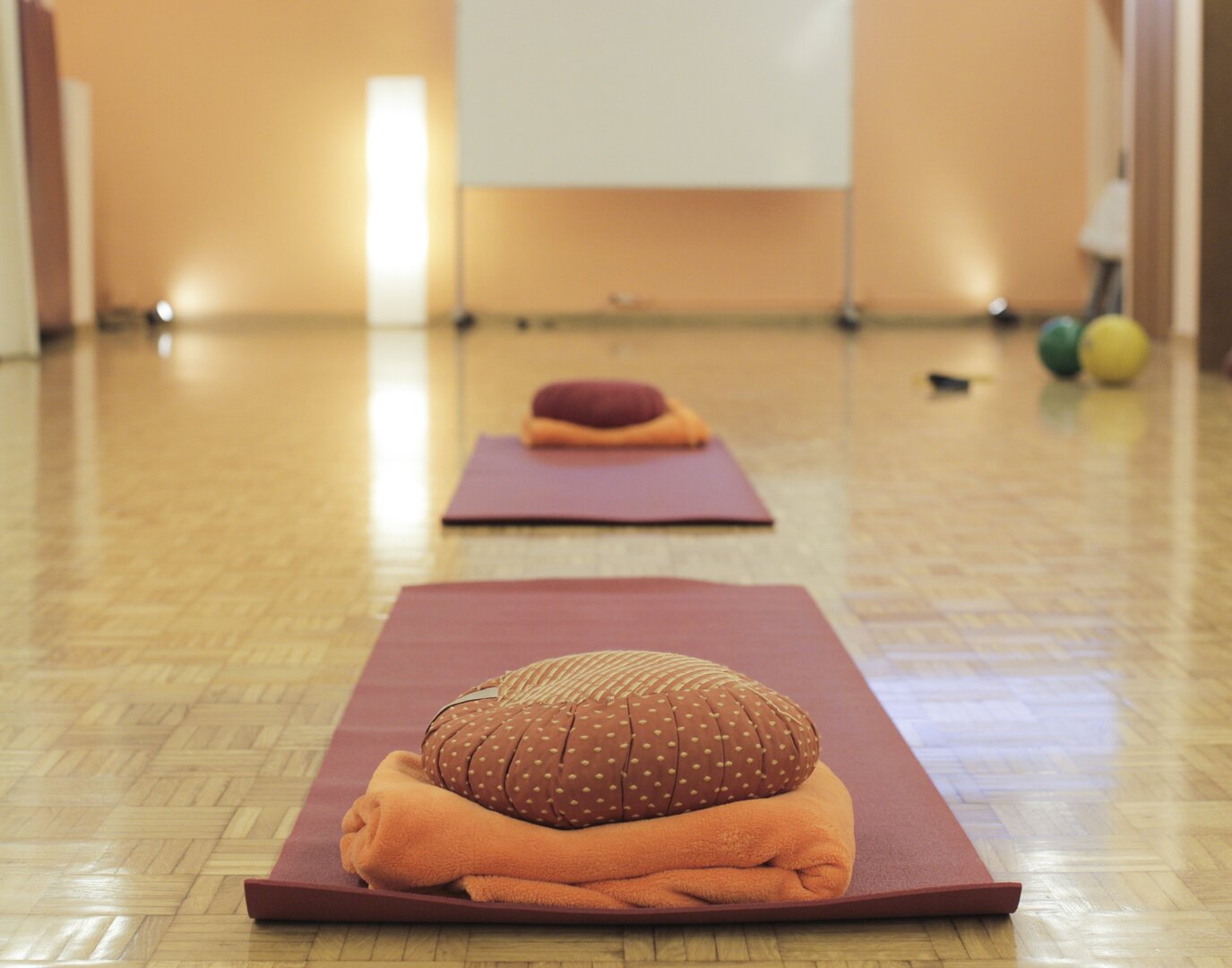 Espacio de práctica con esterilla y cojín para sesiones de bienestar | Método Estar Bé esterilla y cojín de meditación preparados en una sala de práctica de bienestar
