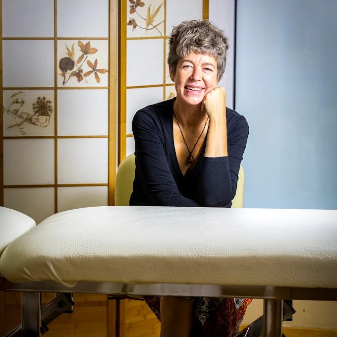 Sesión de terapia corporal con presión manual en espalda durante tratamiento en camilla