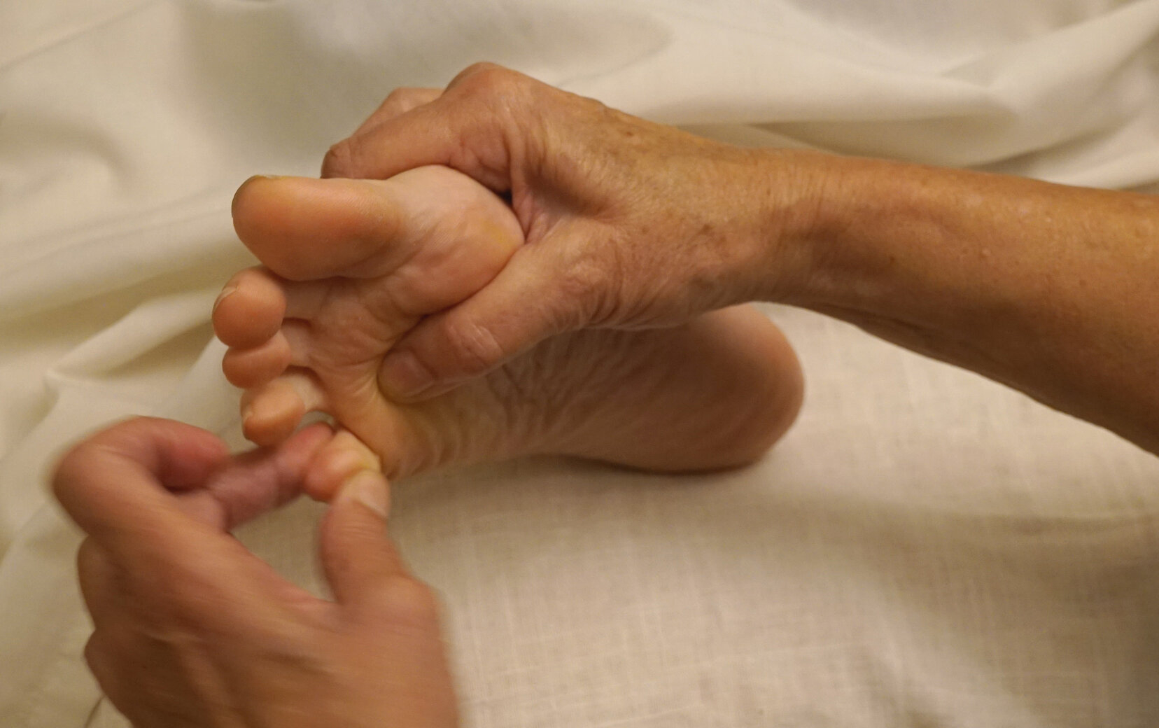 Sesión de reflexología podal con masaje en los dedos del pie sobre camilla